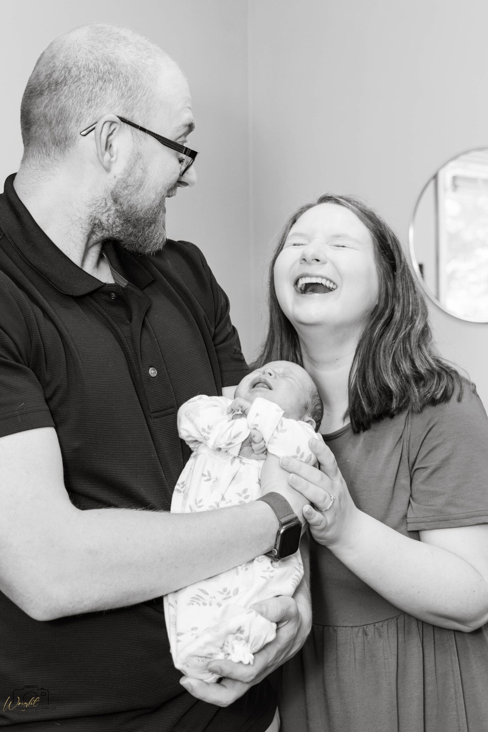 Gage and Emily sharing a laugh while holding Amelia