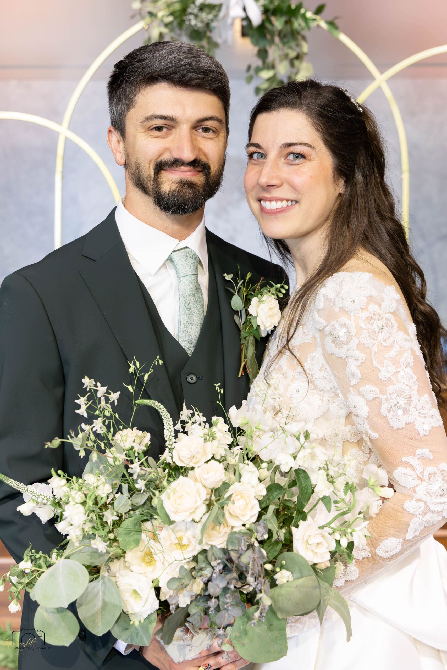 Ryan and Elizabeth looking directly at the camera and smiling at the altar