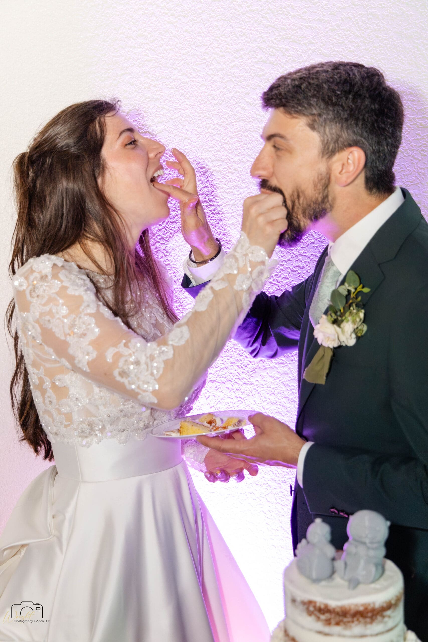 Ryan and Elizabeth laughing as they feed each other cake