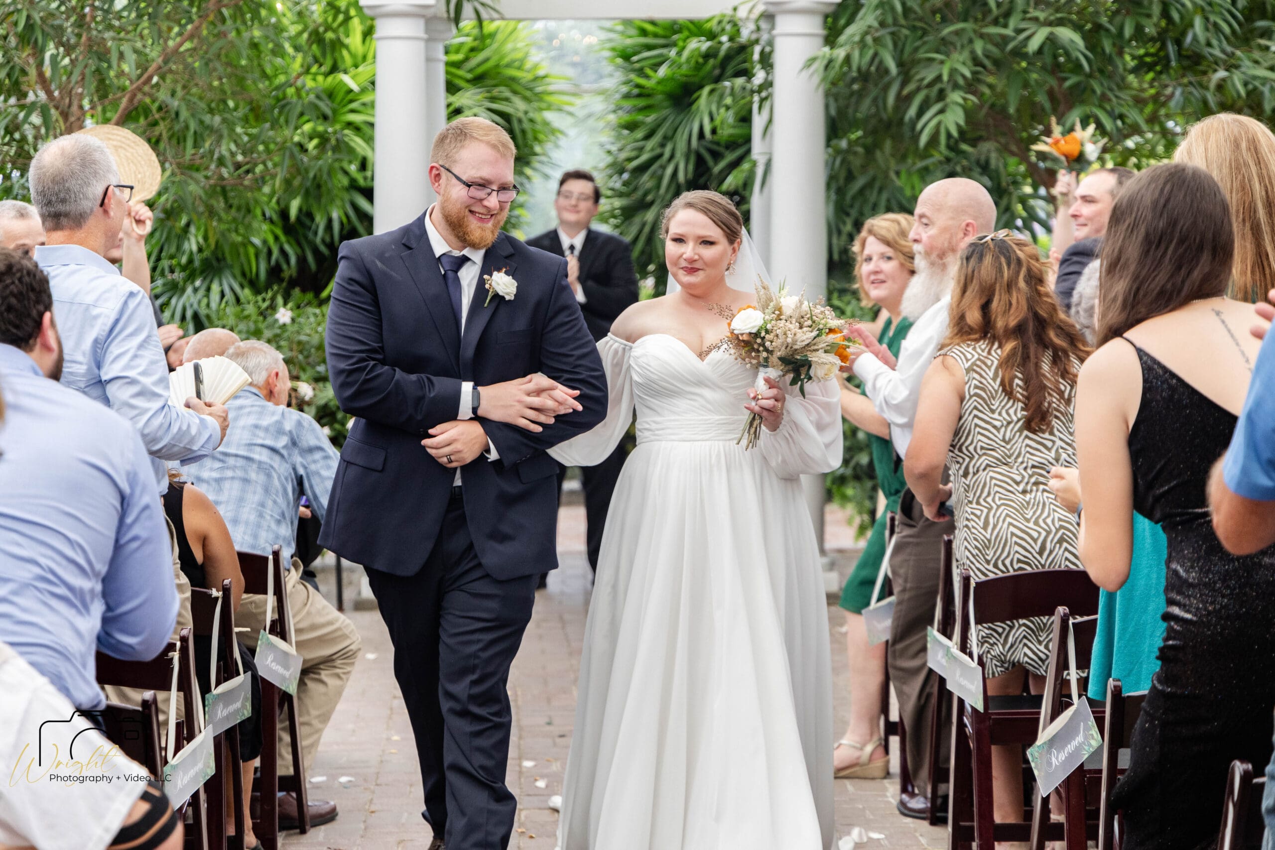 Gage and Emily walking back down the aisle together as husband and wife, guests cheering