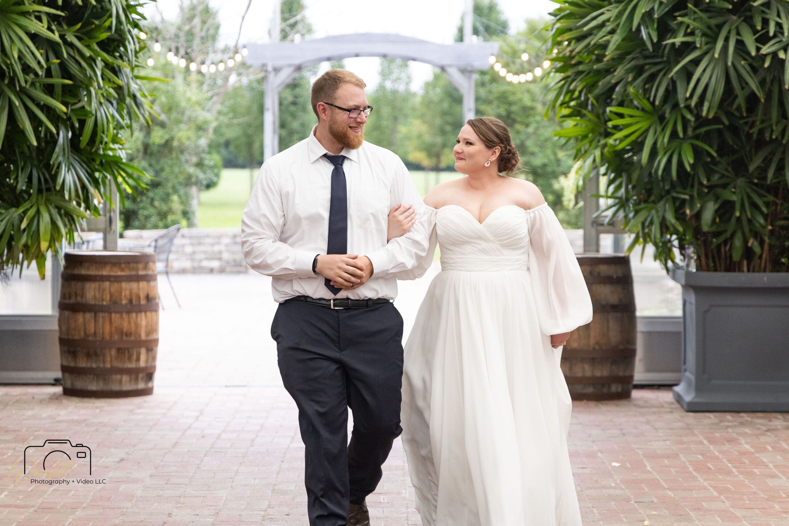 Gage and Emily walking arm in arm from the ceremony into the reception