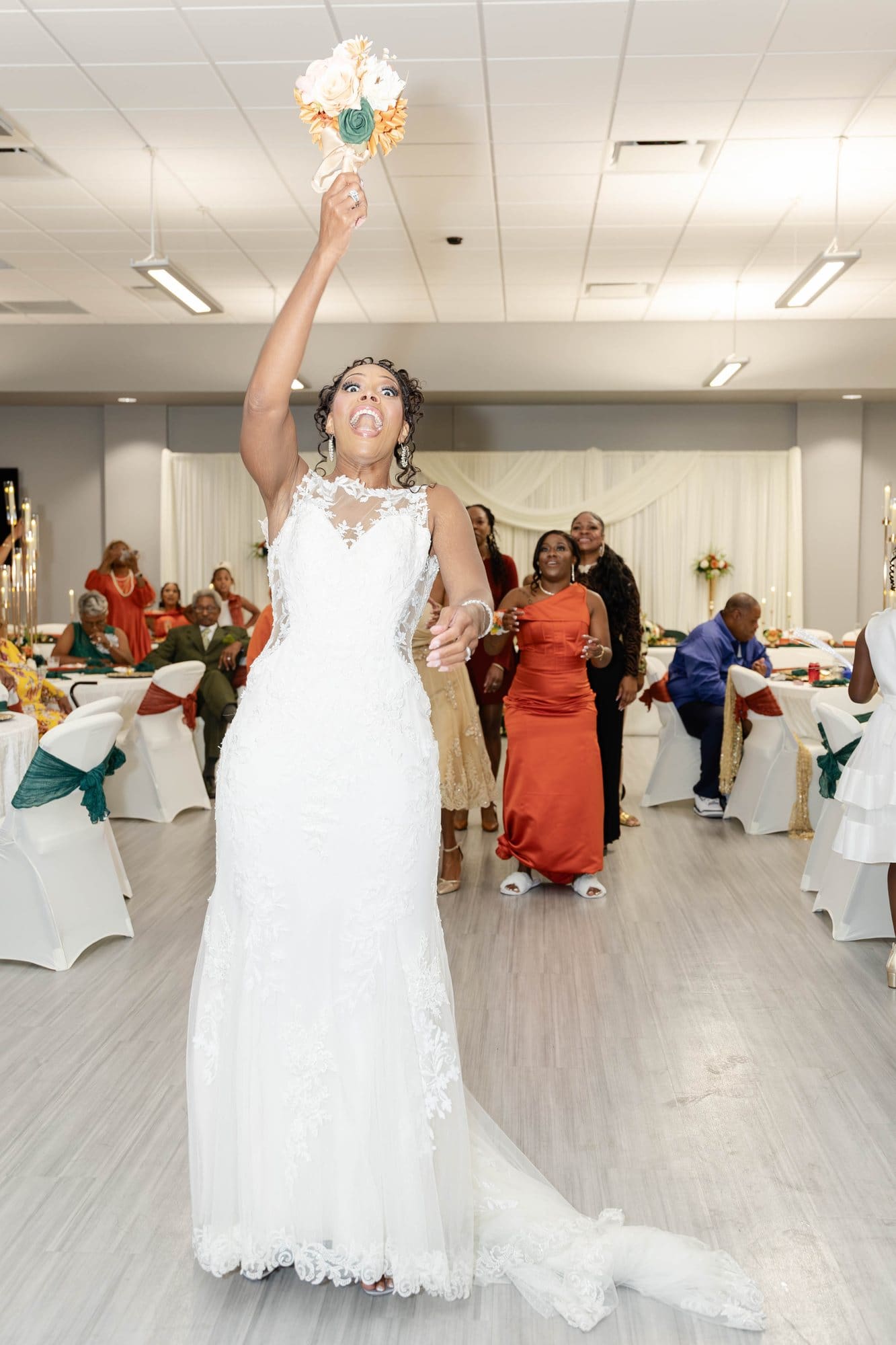 Nikeesha tossing her bouquet high over her shoulder at the reception