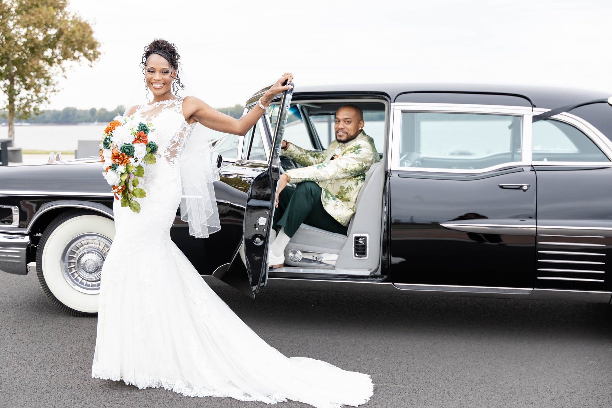 Nikeesha stepping out of a vintage Cadillac Fleetwood while David sits inside on the Paducah riverfront