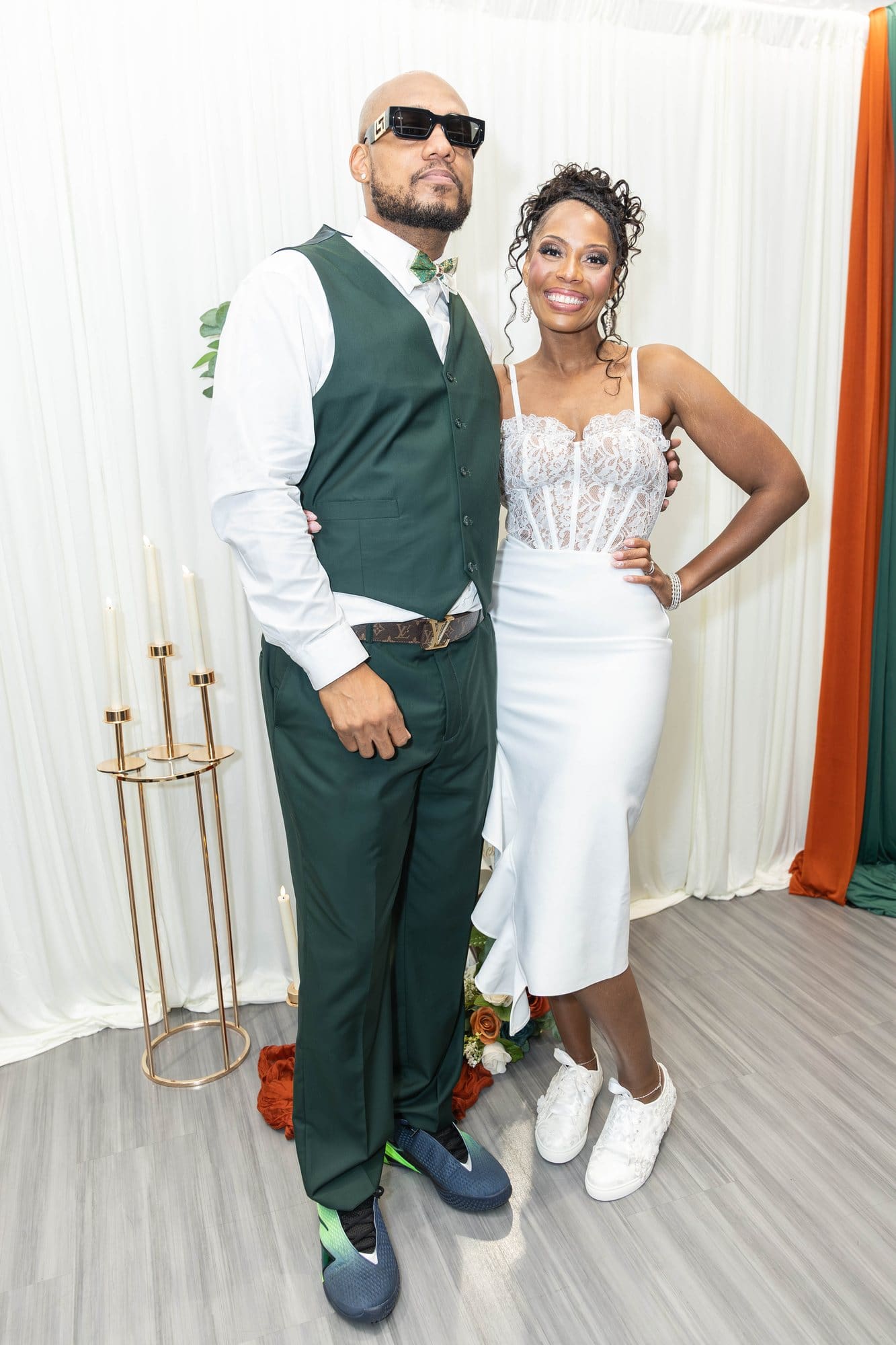 David and Nikeesha smiling together at the reception, Nikeesha in her white reception dress and David in his emerald vest
