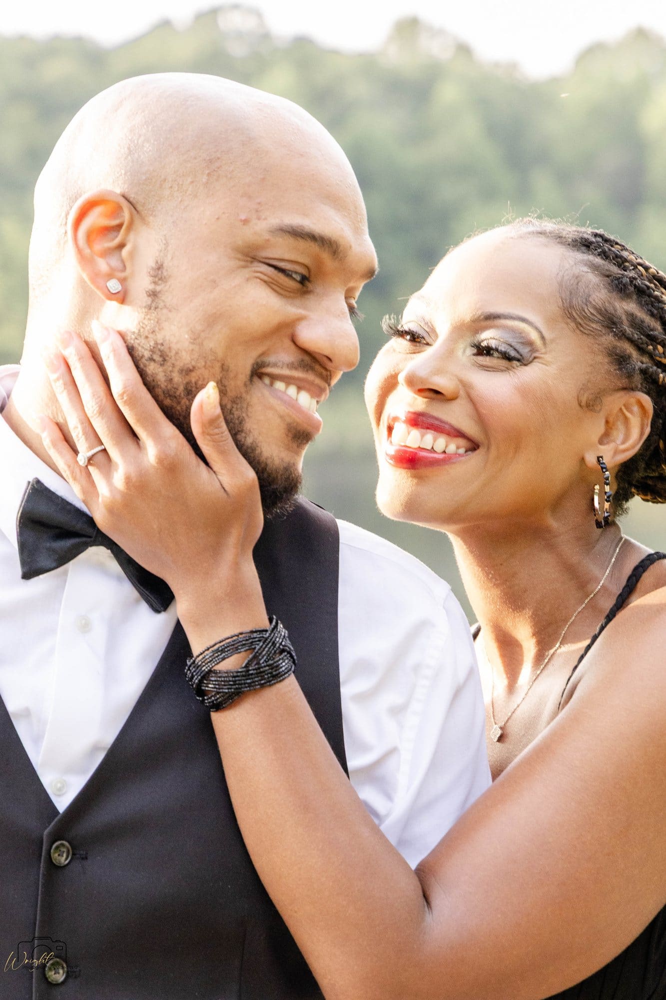 Close portrait of David and Nikeesha laughing together with Duncan Lake behind them at Land Between the Lakes