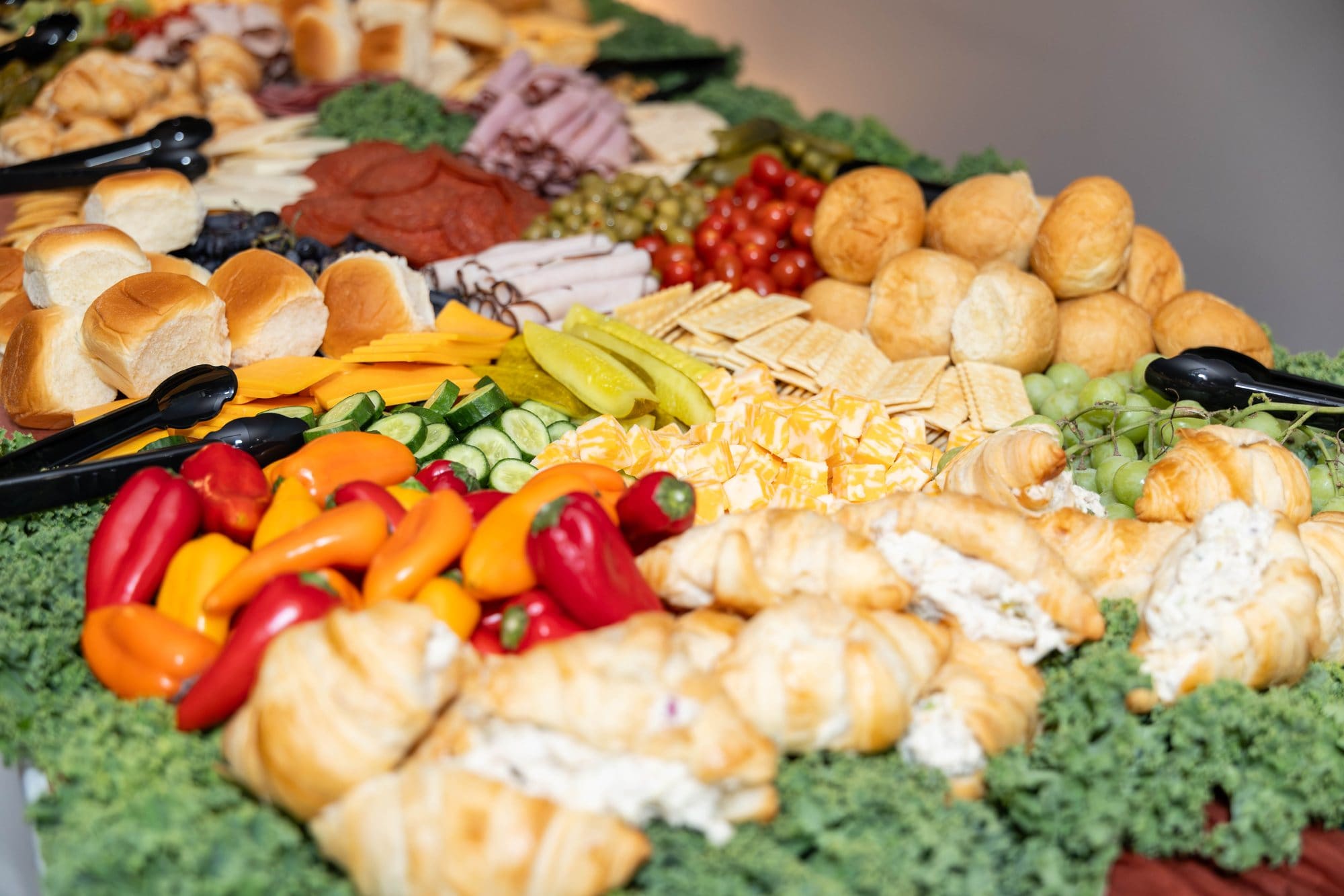 Grazing table with croissants, sliders, charcuterie, peppers and olives from The Southern Spread