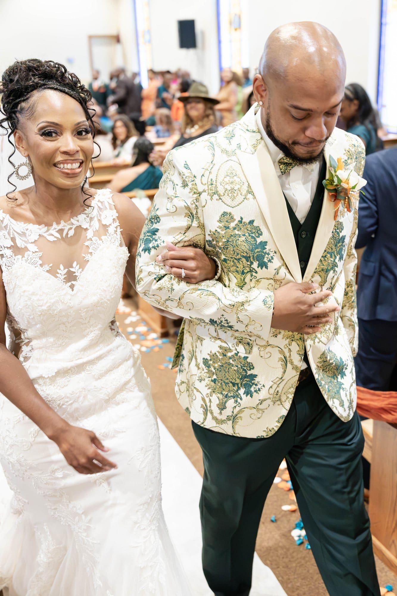 David and Nikeesha smiling as they walk up the aisle as husband and wife