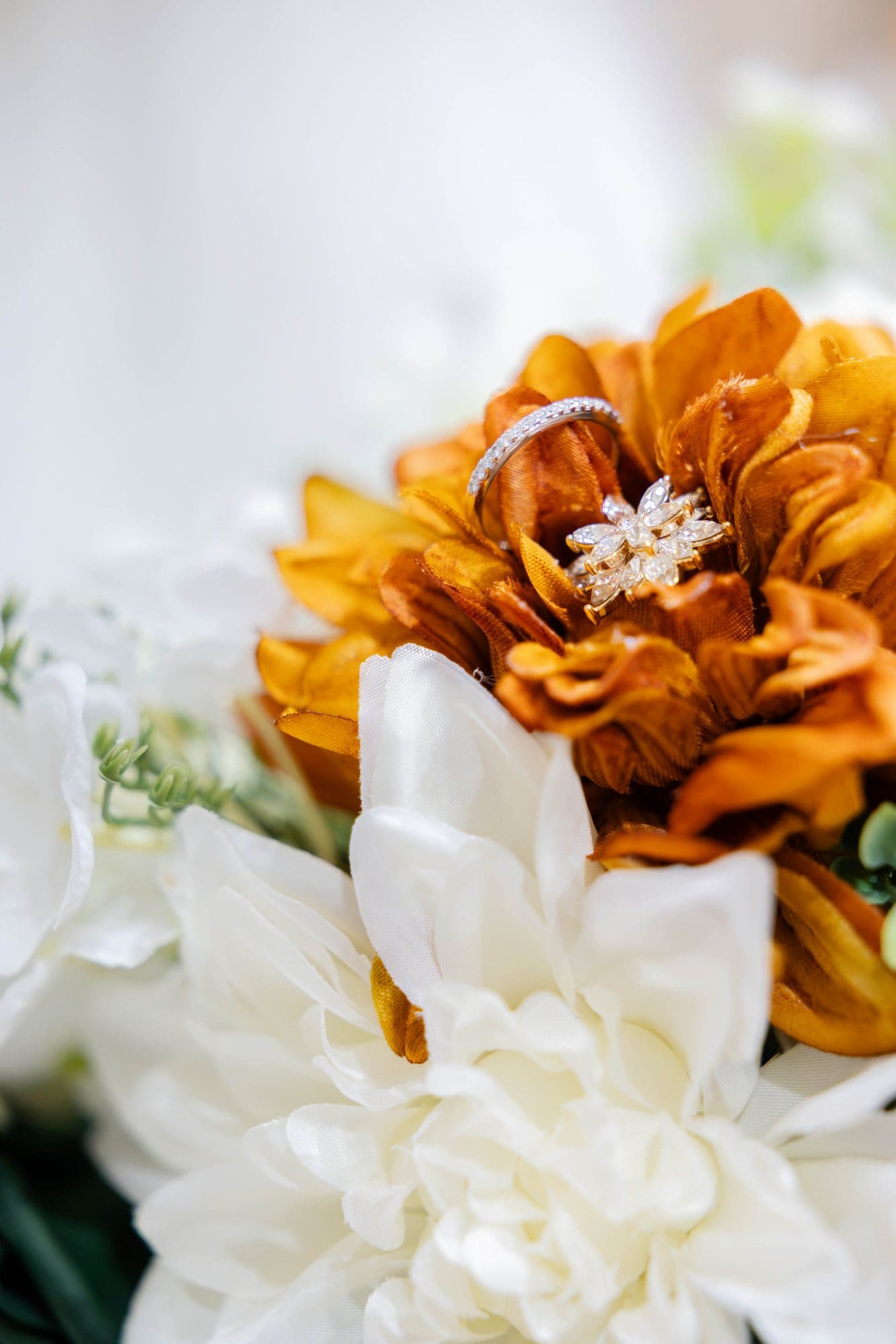 Wedding rings resting in a copper and cream bridal bouquet