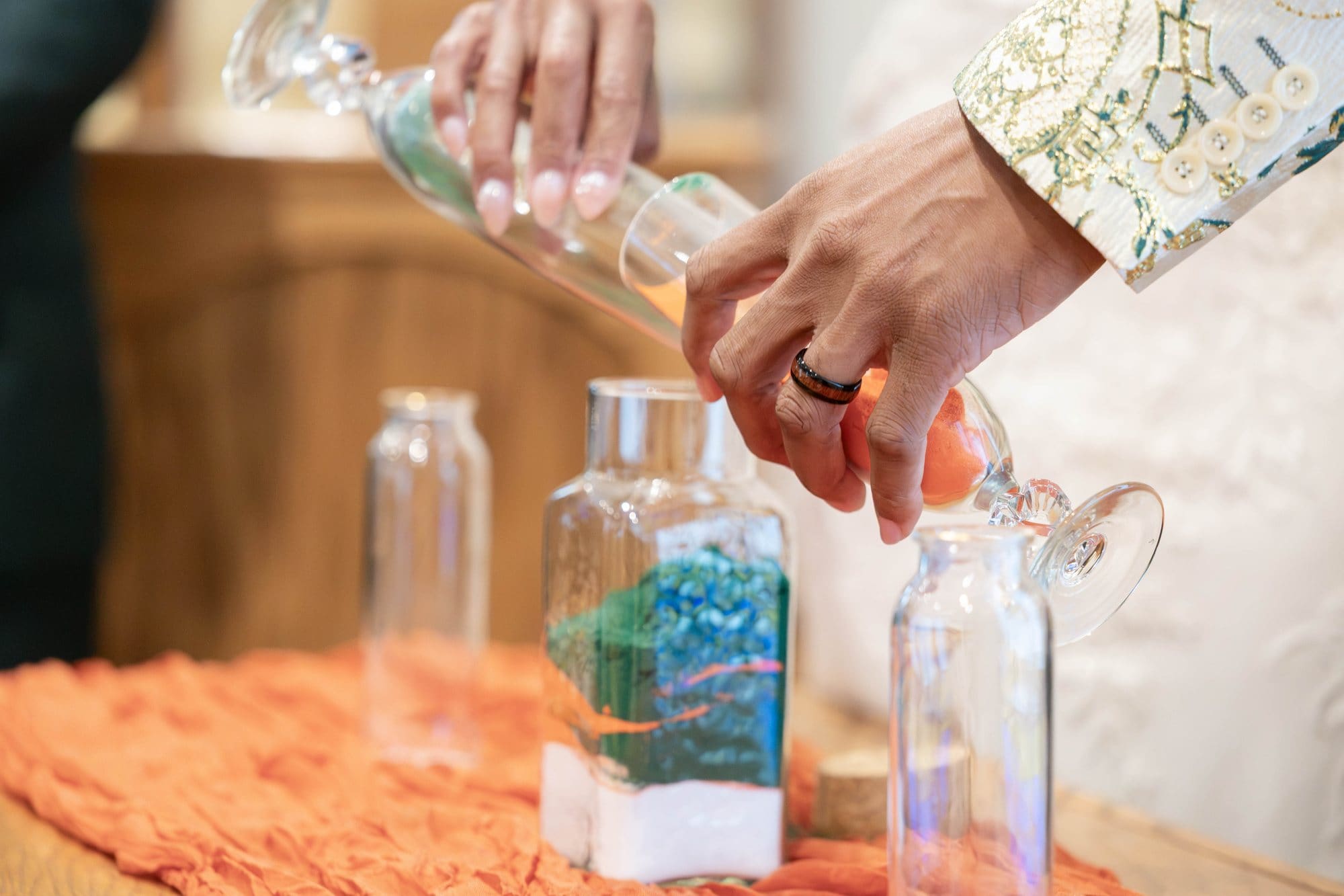 Hands pouring copper sand into the unity vessel on a copper gauze runner