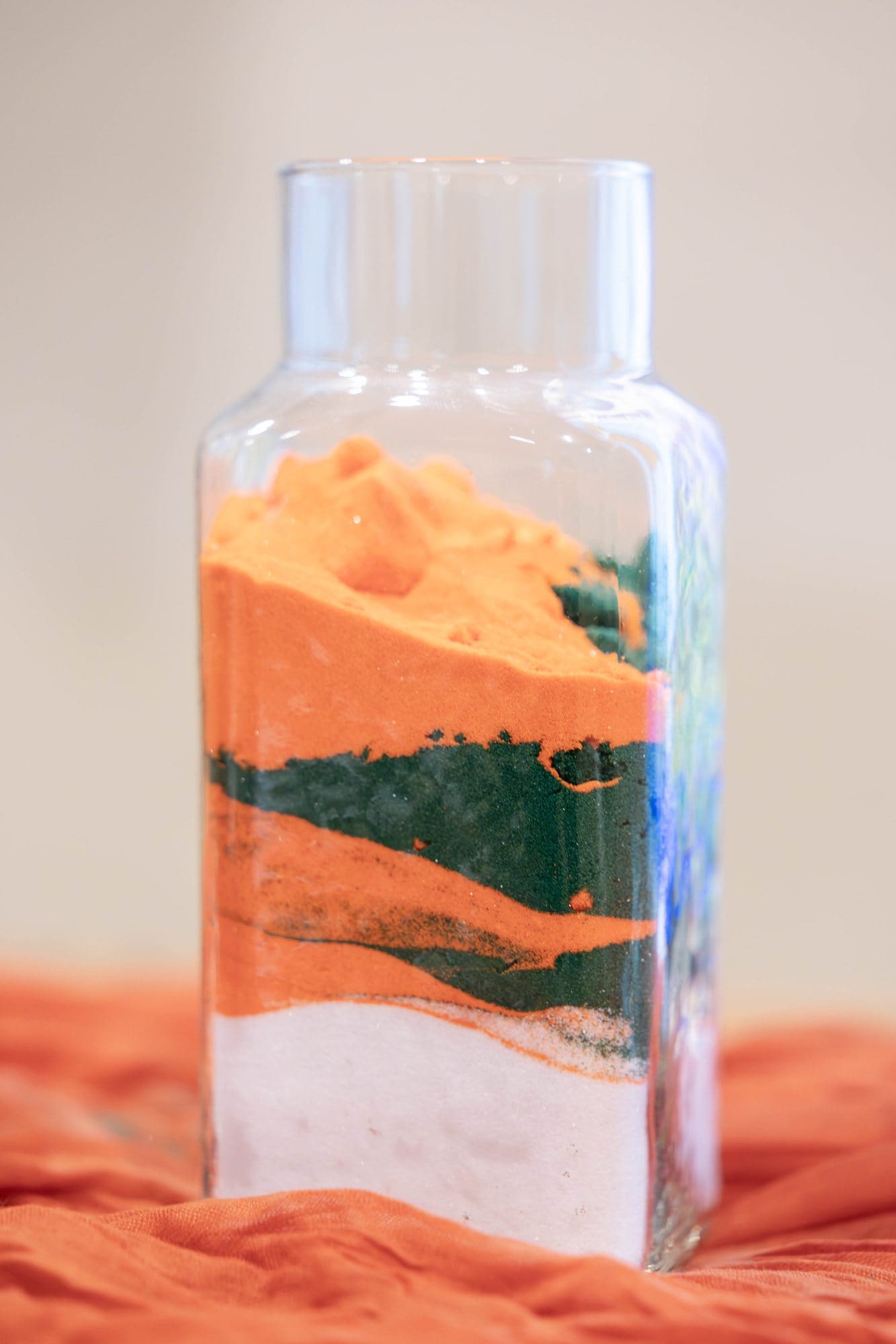 Finished unity sand vessel layered in white, emerald and copper