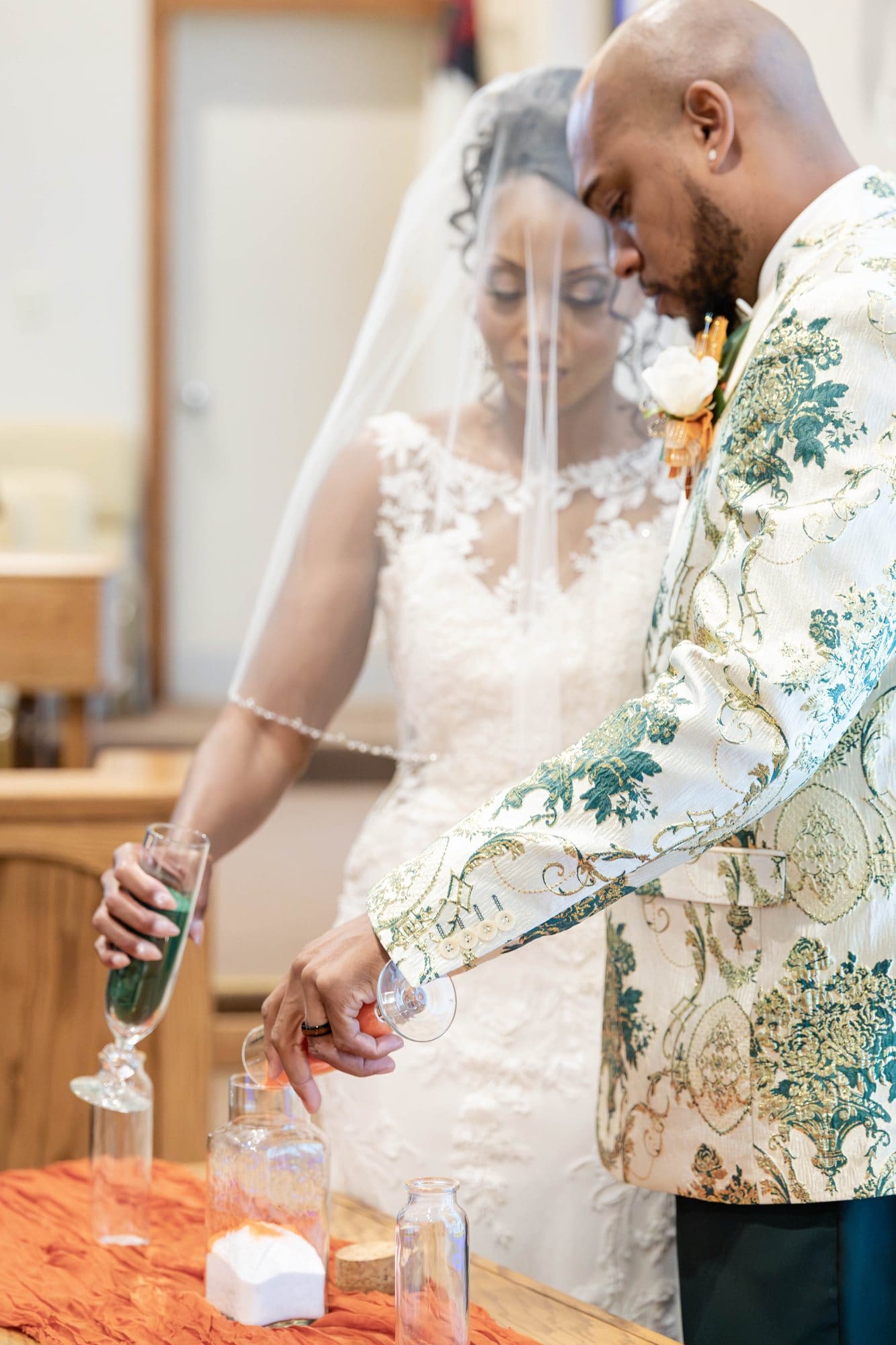 David and Nikeesha pouring emerald sand together during the unity sand ceremony